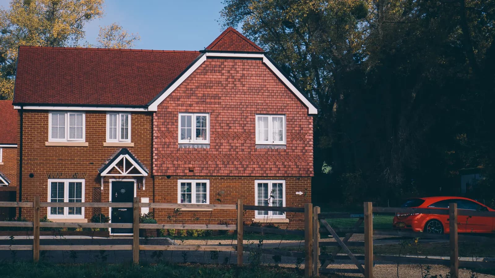 Red-brick English family house with a driveway and a parked car in Farnham, Surrey