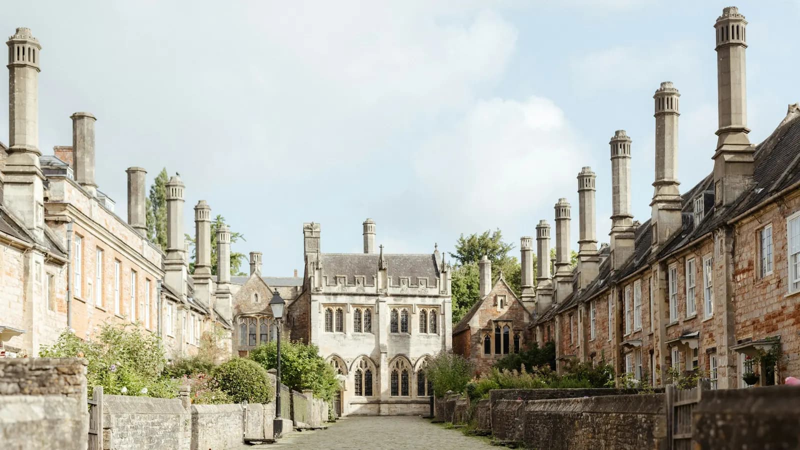 A cobbled lane of medieval stone houses with tall chimneys at Vicars' Close in Wells